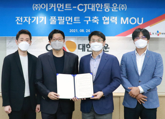 지난 24일 진행된 전자기기 풀필먼트 구축 협력 업무협약에서 노상원 이커먼트 대표(왼쪽부터)와 노영렬 대표, 안재호 CJ대한통운 이커머스 본부장과 정성용 팀장이 협약 체결 후 기념사진을 촬영하고 있다. <CJ대한통운 제공>